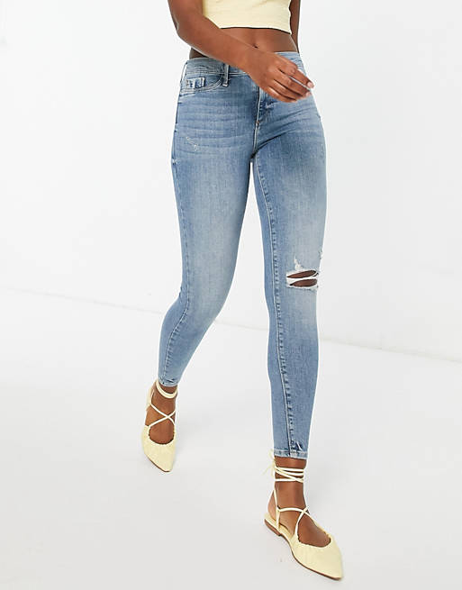 Mid Rise Ripped Knee Skinny Jeans In Medium Blue